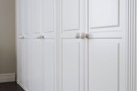 White cabinet doors with brown floor handlesの写真素材