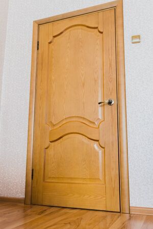 Brown door with gold handle with brown floor texture and white wallの写真素材