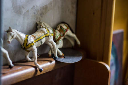 two white and yellow Vintage wooden riding horses on a boardの写真素材