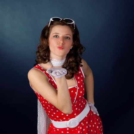 Pretty young girl blowing kiss. Black background.の写真素材
