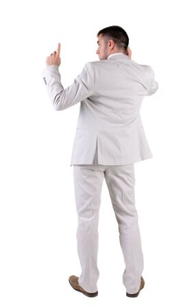 Back view of  thinking young business man in  white suit. Rear view. isolated over white background. Concept of idea, ask question, think up, choose, decide.の写真素材