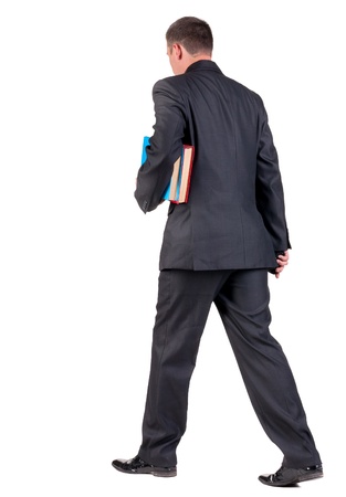 back view of walking  business man with books. going young guy in black suit. Isolated over white background. Rear view people collection. backside view of personの写真素材