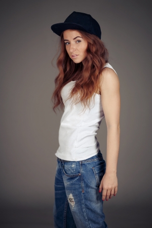 red-haired girl with freckles in the studio. Teen girl with bright red hair in youth clothes.の写真素材