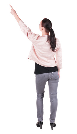 Back view of  pointing woman. beautiful brunette girl in jeans.  Rear view people collection.  backside view of person.  Isolated over white background.の写真素材