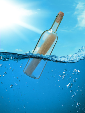 Bottle with a letter from the wreck. A bottle with a note floating in the ocean.の写真素材