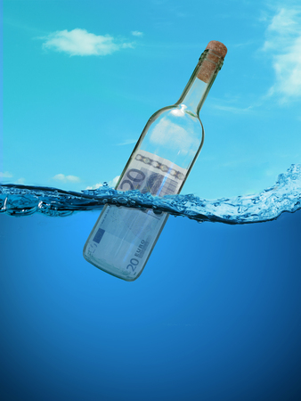 Concept  "financial assistance". Bottle of money floating in the water.の写真素材