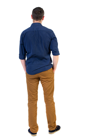 Back view of man . Standing young guy. Rear view people collection.  backside view of person.  Isolated over white background.a man in a blue shirt with the sleeves rolled up, standing with his hands in his pocket.の写真素材