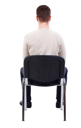 back view of business man sitting on chair. bearded man in a white warm sweater sits on a chair.の写真素材