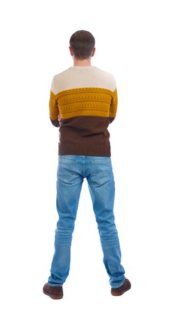 Back view of man in jeans. Standing young guy. Rear view people collection.  backside view of person.  Isolated over white background. The man put his hands behind his back in a warm sweater.の写真素材