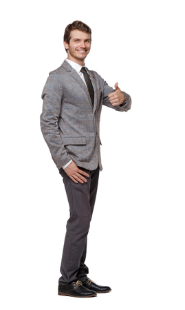 Front view of business man thumbs up. Isolated over white . Front view people collection. Isolated over white background. Young businessman in a suit shows a sign of success.の写真素材