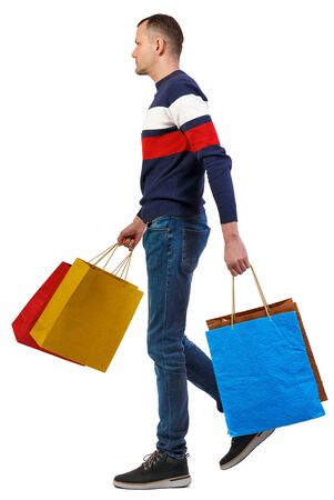 Side view of going man with shopping bags. guy in motion. backside view of person. Rear view people collection. Isolated over white backgroundの写真素材
