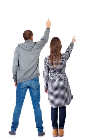 Back view of a stylish couple pointing. beautiful friendly girl and guy together. Rear view people collection. backside view of person. Isolated over white background.の写真素材