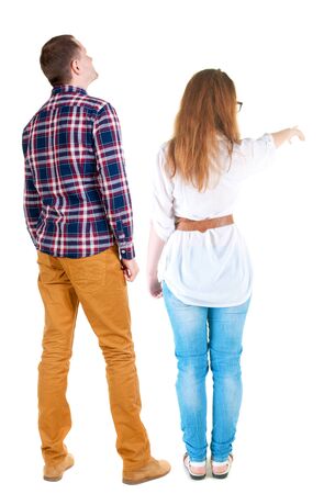 Back view of a stylish couple pointing. beautiful friendly girl and guy together. Rear view people collection. backside view of person. Isolated over white background.の写真素材