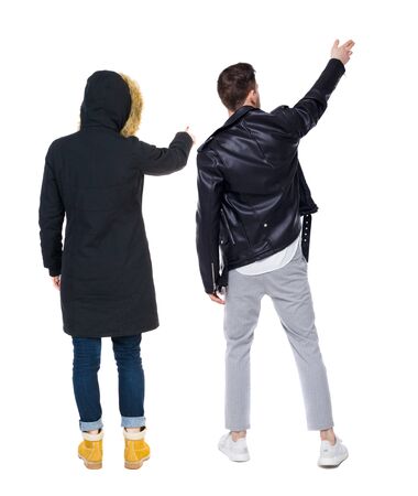 Back view of couple couple in winter jackets pointing. beautiful friendly girl and guy together. Rear view people collection. backside view of person. Isolated over white background.の写真素材