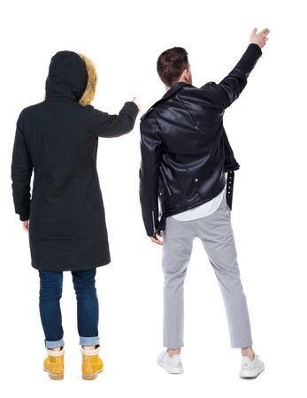 Back view of couple couple in winter jackets pointing. beautiful friendly girl and guy together. Rear view people collection. backside view of person. Isolated over white background.の写真素材