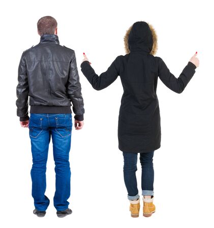Back view of couple couple in winter jackets showing thumbs up. beautiful friendly girl and guy together. Rear view people collection. backside view of person. Isolated over white background.の写真素材
