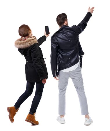 Back view of couple in winter jacket photographed on a mobile phone in winter jacket. beautiful friendly girl and guy together. Rear view people collection. backside view of person. Isolated over white background.の写真素材
