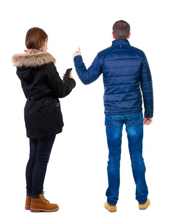 Back view of couple in winter jacket photographed on a mobile phone in winter jacket. beautiful friendly girl and guy together. Rear view people collection. backside view of person. Isolated over white background.の写真素材