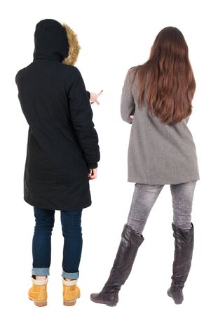 Back view of couple couple in winter jackets pointing. beautiful friendly girl and guy together. Rear view people collection. backside view of person. Isolated over white background.の写真素材