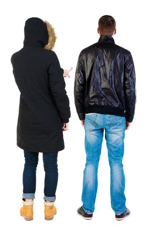 Back view of couple couple in winter jackets pointing. beautiful friendly girl and guy together. Rear view people collection. backside view of person. Isolated over white background.の写真素材