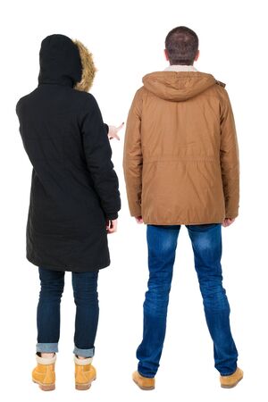 Back view of couple couple in winter jackets pointing. beautiful friendly girl and guy together. Rear view people collection. backside view of person. Isolated over white background.の写真素材
