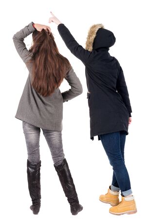 Back view of couple couple in winter jackets pointing. beautiful friendly girl and guy together. Rear view people collection. backside view of person. Isolated over white background.の写真素材