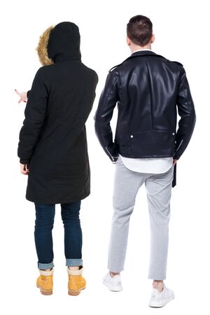 Back view of couple couple in winter jackets pointing. beautiful friendly girl and guy together. Rear view people collection. backside view of person. Isolated over white background.の写真素材