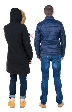 Back view of couple couple in winter jackets pointing. beautiful friendly girl and guy together. Rear view people collection. backside view of person. Isolated over white background.の写真素材