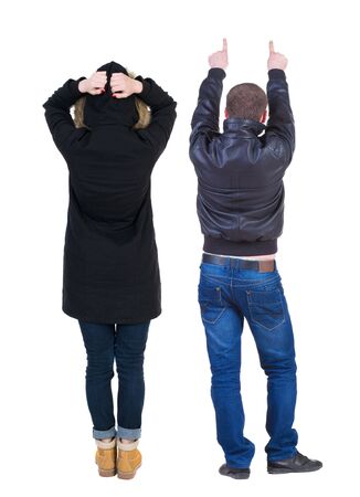 Back view of couple couple in winter jackets pointing. beautiful friendly girl and guy together. Rear view people collection. backside view of person. Isolated over white background.の写真素材