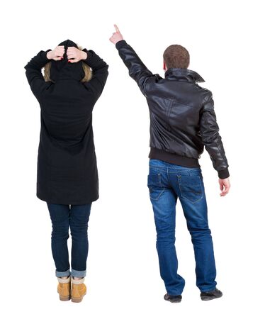 Back view of couple couple in winter jackets pointing. beautiful friendly girl and guy together. Rear view people collection. backside view of person. Isolated over white background.の写真素材