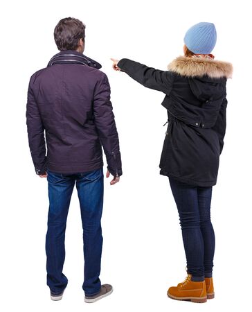 Back view of couple couple in winter jackets pointing. beautiful friendly girl and guy together. Rear view people collection. backside view of person. Isolated over white background.の写真素材