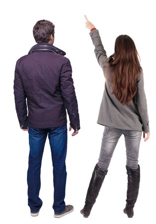 Back view of couple couple in winter jackets pointing. beautiful friendly girl and guy together. Rear view people collection. backside view of person. Isolated over white background.の写真素材