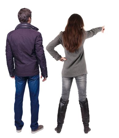 Back view of couple couple in winter jackets pointing. beautiful friendly girl and guy together. Rear view people collection. backside view of person. Isolated over white background.の写真素材