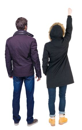 Back view of couple couple in winter jackets pointing. beautiful friendly girl and guy together. Rear view people collection. backside view of person. Isolated over white background.の写真素材