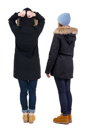 Back view of couple couple in winter jackets pointing. beautiful friendly girl and guy together. Rear view people collection. backside view of person. Isolated over white background.の写真素材