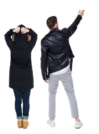 Back view of couple couple in winter jackets pointing. beautiful friendly girl and guy together. Rear view people collection. backside view of person. Isolated over white background.の写真素材