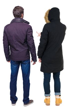 Back view of couple couple in winter jackets pointing. beautiful friendly girl and guy together. Rear view people collection. backside view of person. Isolated over white background.の写真素材