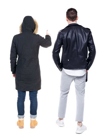 Back view of couple couple in winter jackets pointing. beautiful friendly girl and guy together. Rear view people collection. backside view of person. Isolated over white background.の写真素材