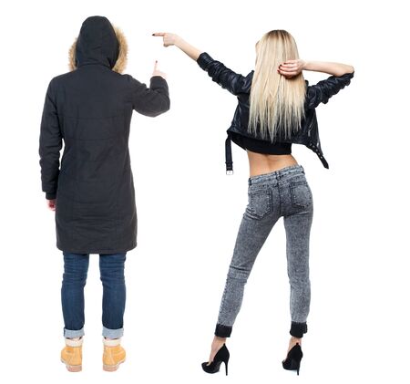 Back view of two pointing young girl in winter jacket. Rear view people collection. backside view of person. beautiful woman friends showing gesture. Rear view. Isolated over white background.の写真素材
