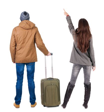 young couple in winter jacket traveling with suitcas. Back view. Rear view people collection. backside view of person. Isolated over white background.の写真素材
