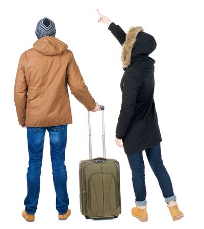 young couple in winter jacket traveling with suitcas. Back view. Rear view people collection. backside view of person. Isolated over white background.の写真素材