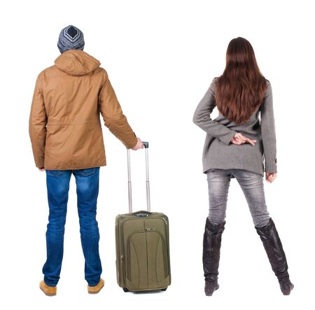 young couple in winter jacket traveling with suitcas. Back view. Rear view people collection. backside view of person. Isolated over white background.の写真素材