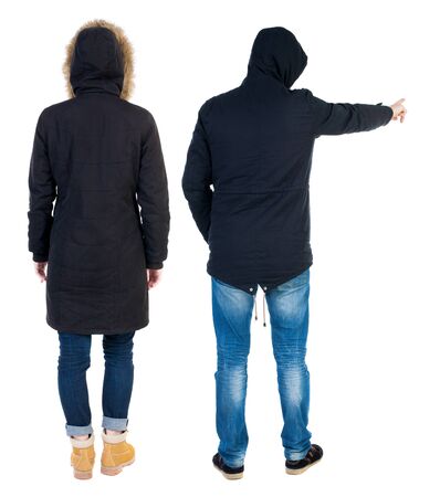 Back view of couple couple in winter jackets pointing. beautiful friendly girl and guy together. Rear view people collection. backside view of person. Isolated over white background.の写真素材