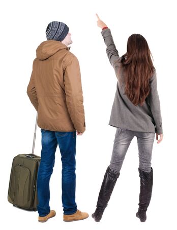 young couple in winter jacket traveling with suitcas. Back view. Rear view people collection. backside view of person. Isolated over white background.の写真素材