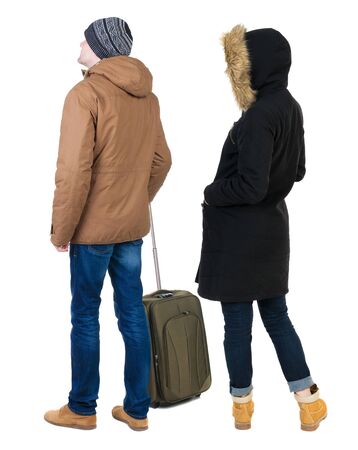 young couple in winter jacket traveling with suitcas. Back view. Rear view people collection. backside view of person. Isolated over white background.の写真素材