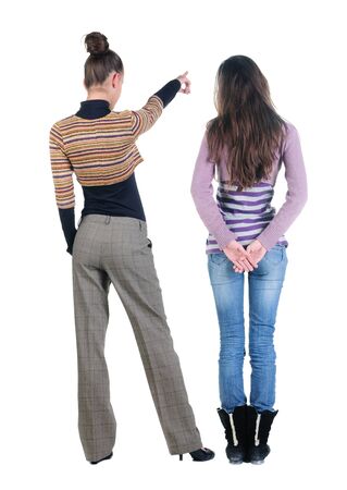Back view of two pointing young girl in sweater. Rear view people collection. backside view of person. beautiful woman friends showing gesture. Rear view. Isolated over white background.の写真素材