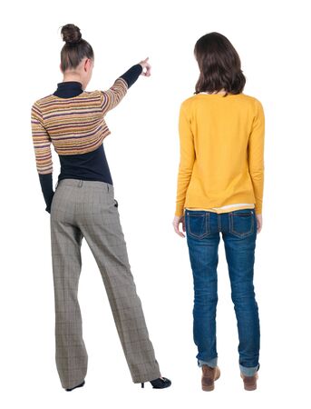 Back view of two pointing young girl in sweater. Rear view people collection. backside view of person. beautiful woman friends showing gesture. Rear view. Isolated over white background.の写真素材