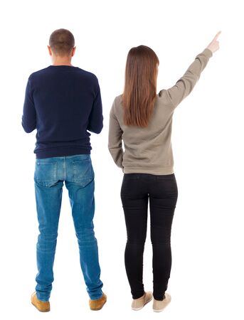 Back view of couple couple in sweater pointing. beautiful friendly girl and guy together. Rear view people collection. backside view of person. Isolated over white background.の写真素材
