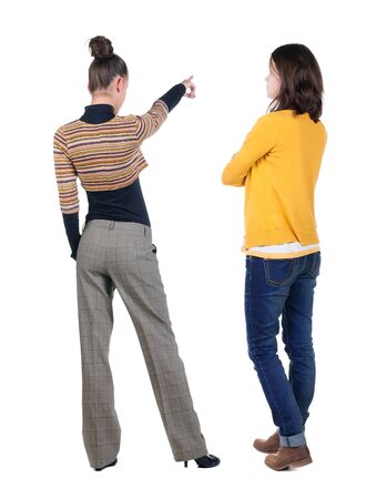 Back view of two pointing young girl in sweater. Rear view people collection. backside view of person. beautiful woman friends showing gesture. Rear view. Isolated over white background.の写真素材