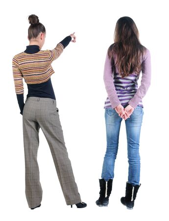 Back view of two pointing young girl in sweater. Rear view people collection. backside view of person. beautiful woman friends showing gesture. Rear view. Isolated over white background.の写真素材